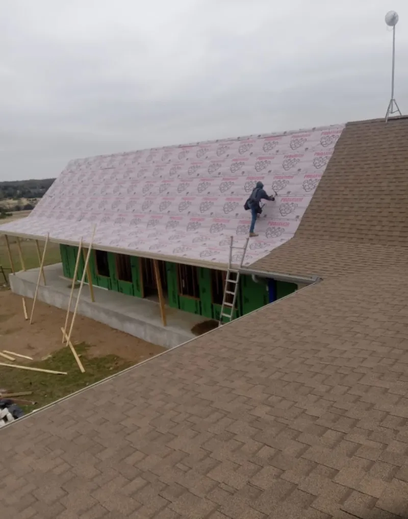 Worker preparing underlayment for a metal roof installation in Goodlettsville